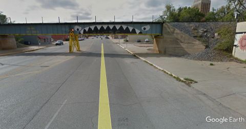 1965 Ford Mustang - A bridge painted to look like a shark's mouth looms over a road with traffic.