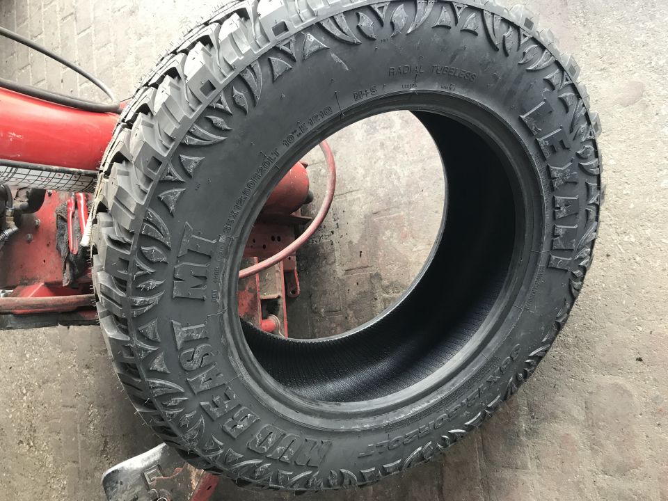 Tire with aggressive tread pattern, radial tubeless, with text 'MT' and 'LEXANI' visible