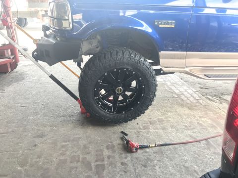 1996 Ford Bronco - Front wheel and tire of a 1996 Ford Bronco undergoing service.