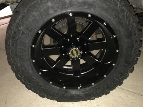 1996 Ford Bronco - Close-up of a black aftermarket wheel and tire assembly, likely for an off-road vehicle.