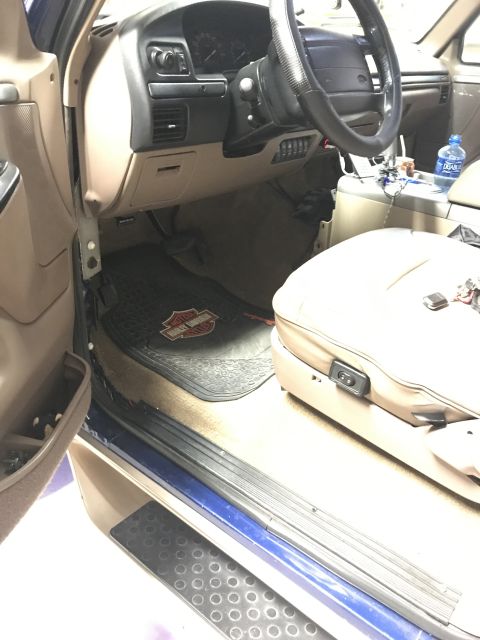 1996 Ford Bronco - The interior of a vehicle, likely from the 1990s, is shown from the driver's side door.