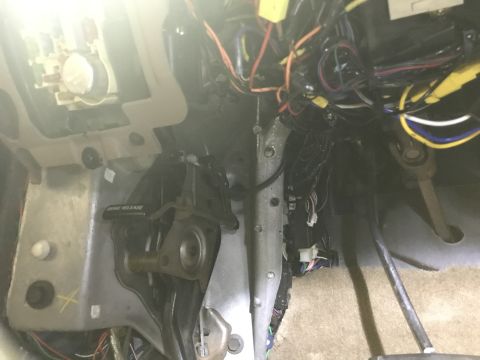 1996 Ford Bronco - A complex web of wires and components are visible under the dashboard of a vehicle.