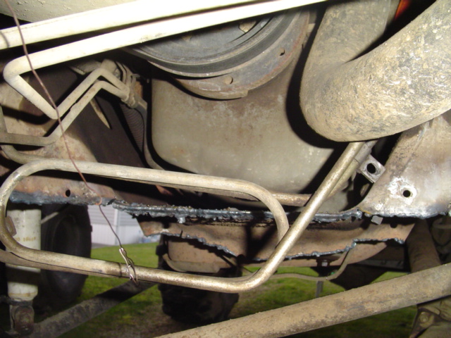 Underside view of vehicle frame with fuel lines and suspension components visible