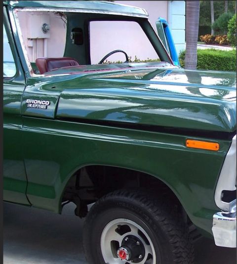 1978 Ford Bronco - Detail of a green 1978 Ford Bronco Custom, showing the fender, hood, and side badge.