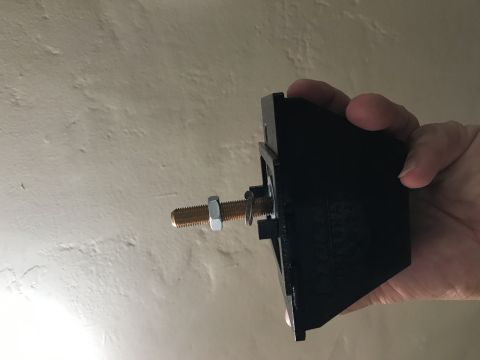 1997 Dodge 3500 - A black plastic component, likely a vehicle part, is held in a hand, showing a threaded bolt and nut assembly.