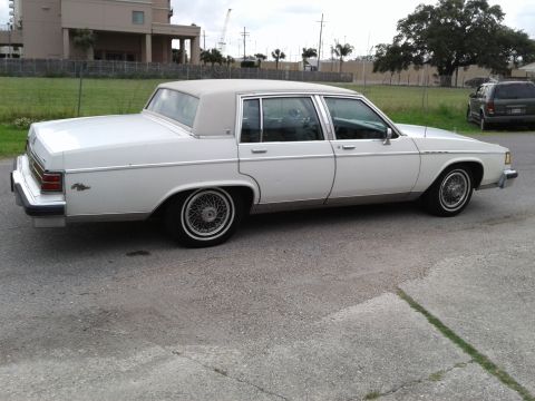 1984 Buick Electra - Side view of a white 1984 Buick Electra sedan with a tan vinyl roof and wire wheels.