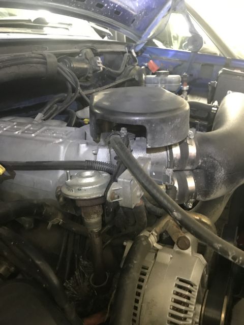 1996 Ford Bronco - This image shows a close-up view of engine components, specifically the EGR valve and alternator, within a vehicle's engine bay.