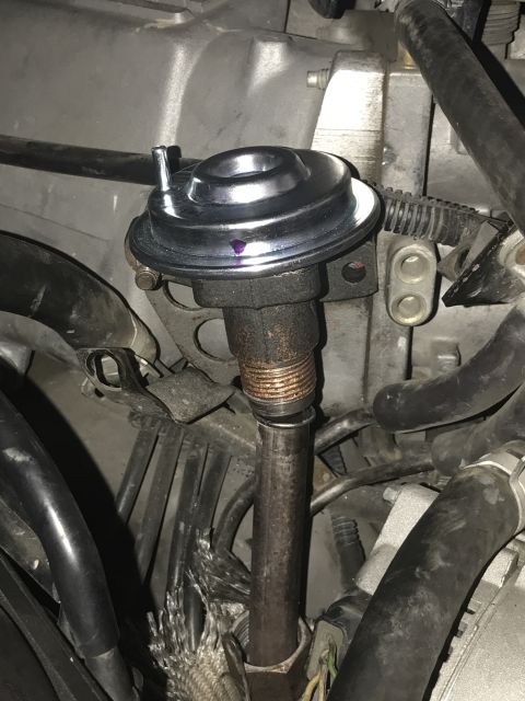 1996 Ford Bronco - Close-up view of an EGR valve assembly in an engine bay.
