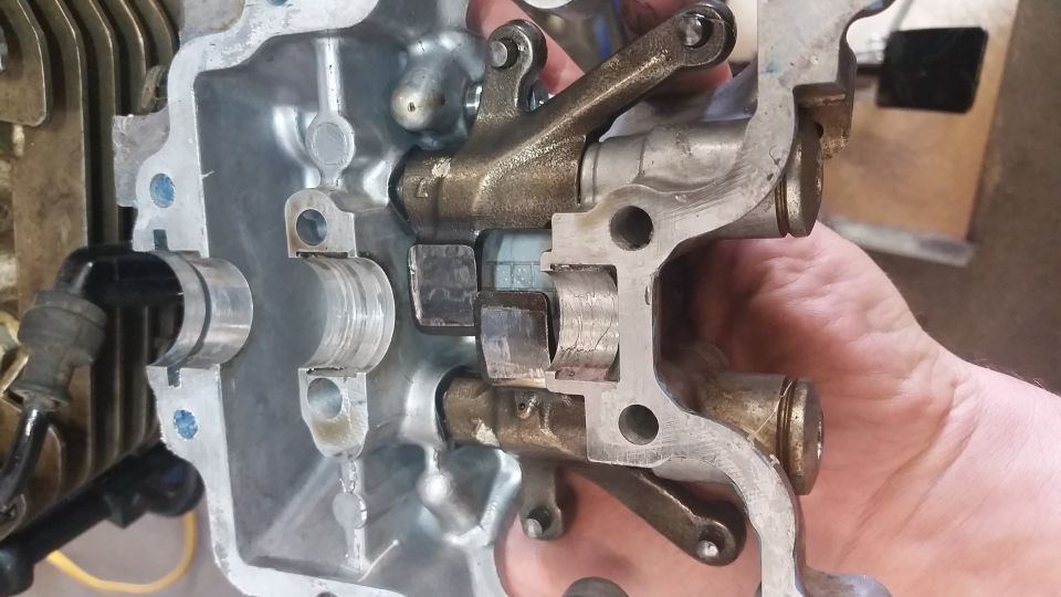 Close-up of motorcycle engine valve train with rocker arms and valve stems visible