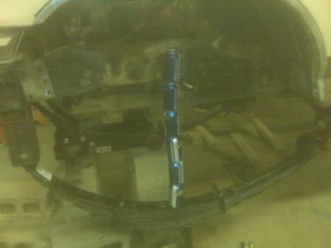 1988 Ford Bronco - Leaf spring assembly with stacked cans for scale, showing suspension components.
