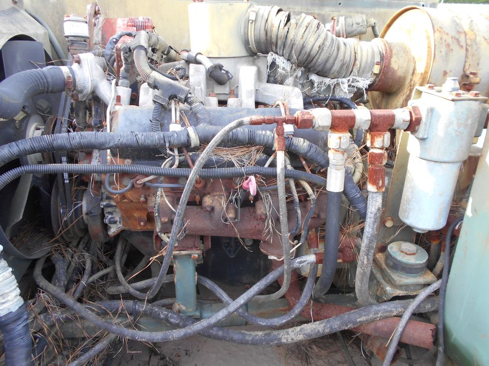 Engine compartment with rusted components and exposed wiring