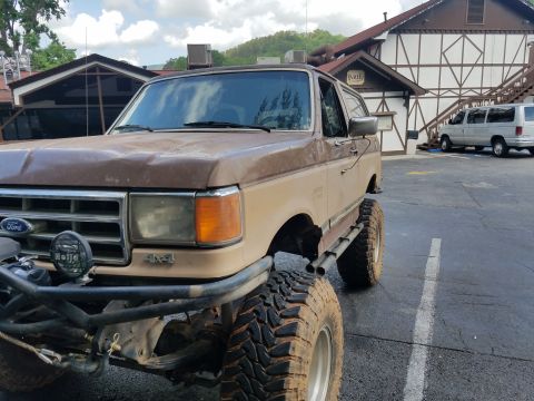 1988 Ford Bronco - This lifted 1988 Ford Bronco is parked in front of a building with a Bavarian-style facade.
