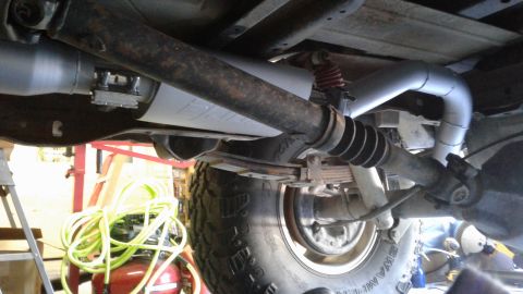 1985 Ford Bronco - Undercarriage view showing the exhaust system and leaf springs of a vehicle.