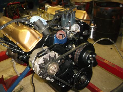 1964 Ford Galaxie - V8 engine with gold valve covers and black block, mounted on a red engine stand.