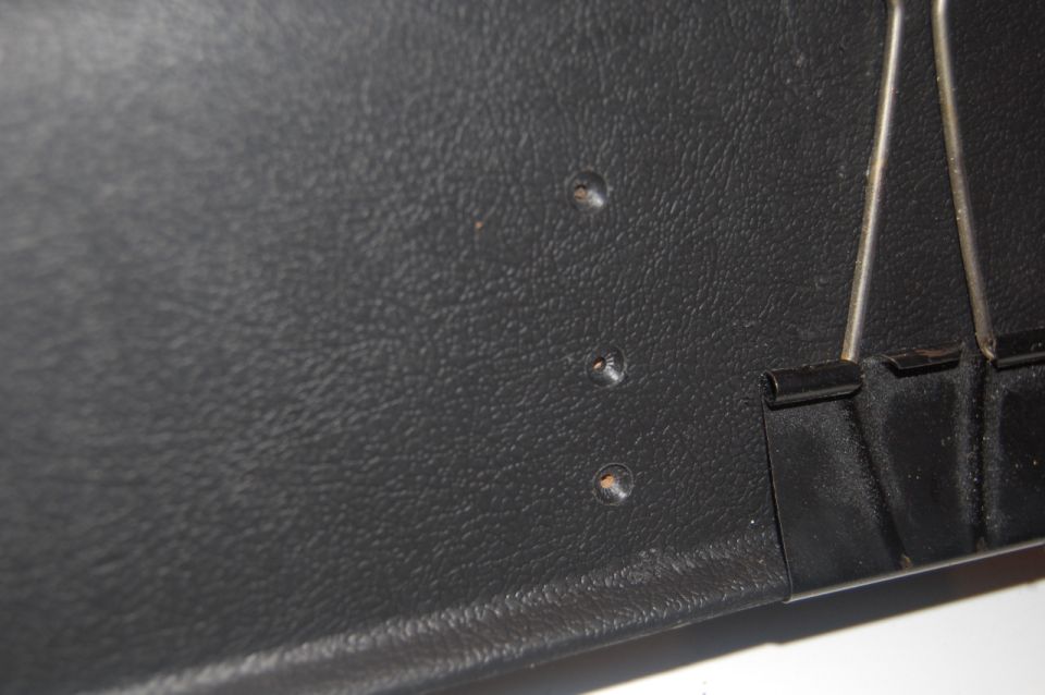 Black door panel with three screw holes and binder clip. Supermotors.net logo visible