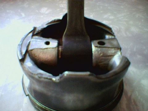 1996 Ford Crown Victoria - A severely damaged piston, likely from an internal engine failure, is shown in close-up.