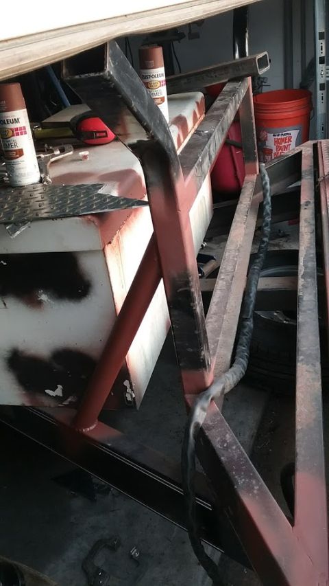 2016 Ford F-250 - A close-up view of a metal frame and tank, with spray paint cans and an orange bucket visible in the background.
