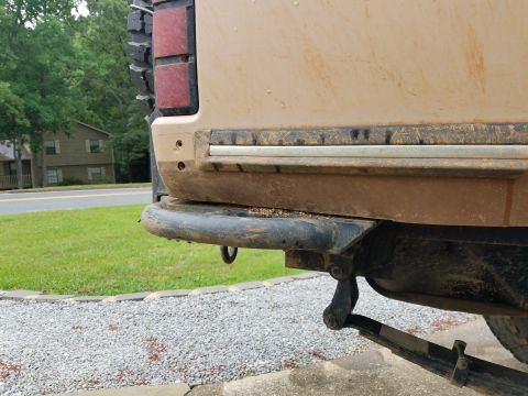1988 Ford Bronco - The rear of a dirty SUV is shown, with a focus on the bumper and taillight assembly.