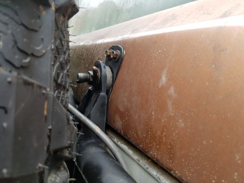 1988 Ford Bronco - Close-up view of a spare tire and its mounting hardware on a vehicle's exterior.