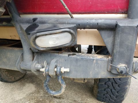 1988 Ford Bronco - Close-up of the rear bumper assembly, showing a tow hook and a clear marker light.
