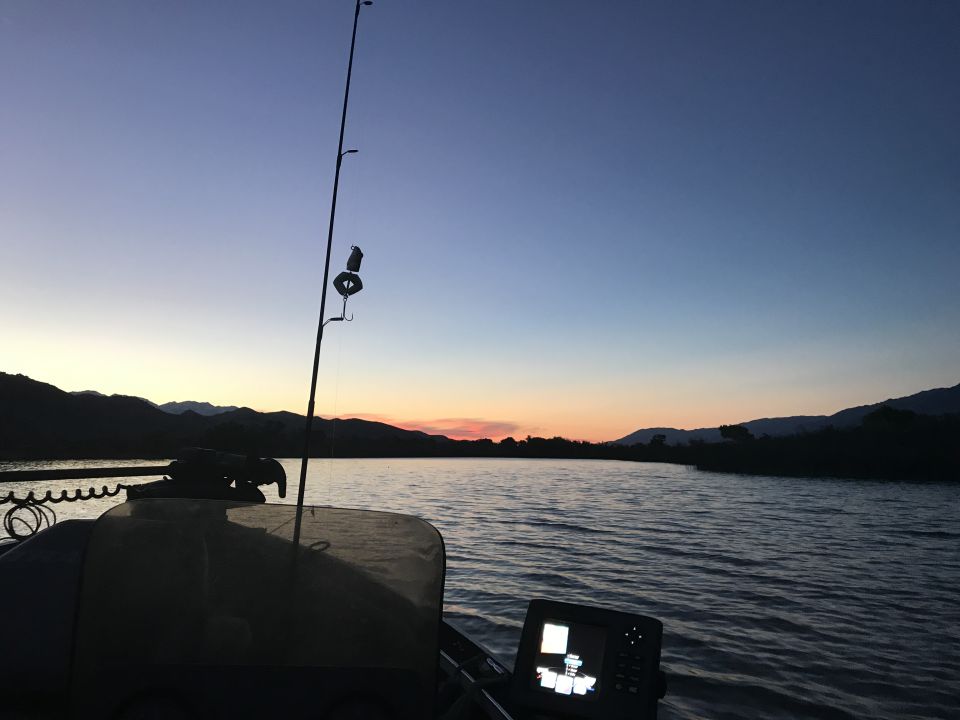 Fishing rod and fish finder on a boat at dusk.
