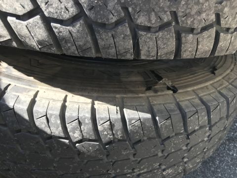1997 Dodge 3500 - A close-up view shows the tread of two stacked tires. The bottom tire has a visible tear in its sidewall.