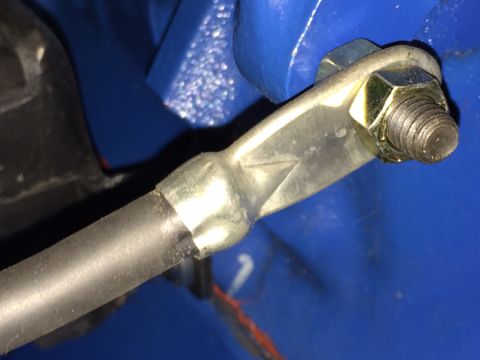 1978 Ford Bronco - A close-up shot shows a metal rod connected to a blue painted component via a bolt and nut assembly. The rod appears to be part of a linkag…