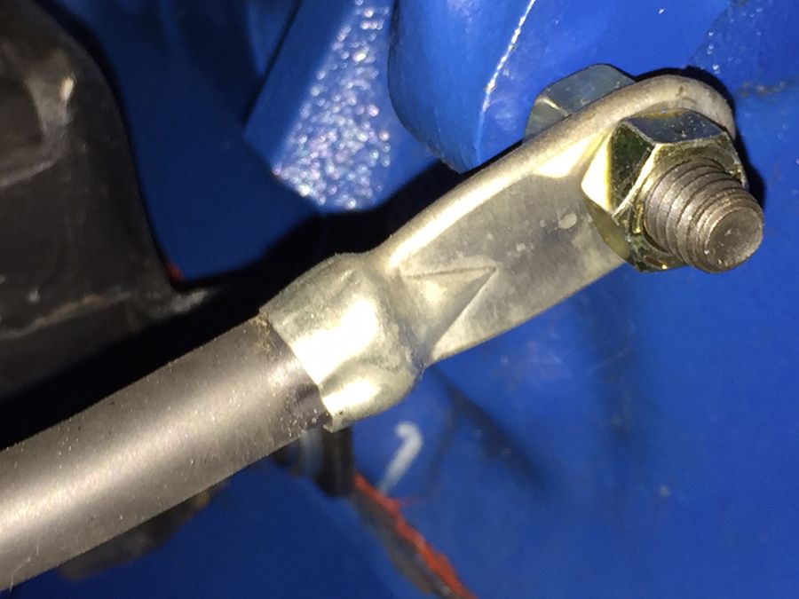Close-up of a metal rod attached to a blue component with a bolt and nut.