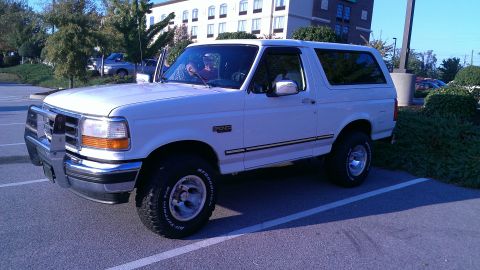 1995 Ford Bronco - This 1995 Ford Bronco is parked in a lot with a building in the background.
