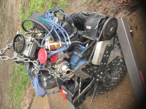 1974 Ford Bronco - Engine and tire assembly, likely for a vehicle, held together with chains.