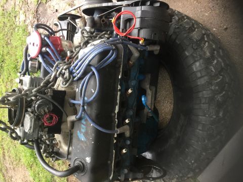 1974 Ford Bronco - Engine components are visible, including spark plug wires and a tire. The engine appears to be a V8.