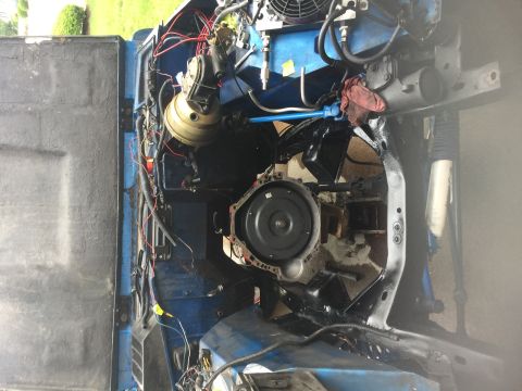 1974 Ford Bronco - The engine bay of a vehicle is shown with the transmission removed, revealing internal components and wiring.