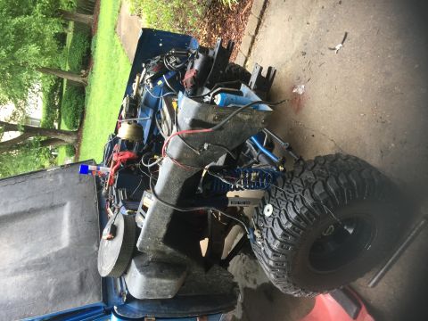 1974 Ford Bronco - Blue SUV with engine exposed and hood open, parked on a concrete surface with grass in the background.