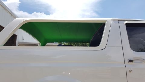1995 Ford Bronco - This 1995 Ford Bronco features a distinctive white exterior and a vibrant green interior headliner.