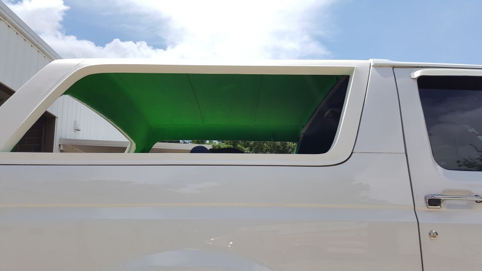 Side view of a white 1995 Ford Bronco with a bright green headliner