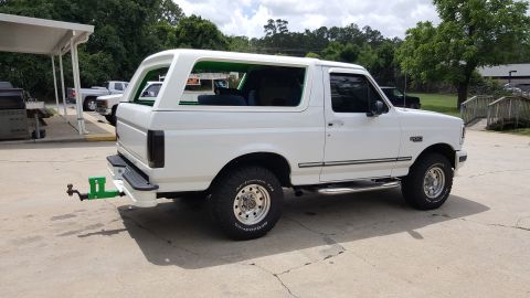 1995 Ford Bronco - White Ford Bronco parked outdoors, showing its side profile and rear hitch attachment.
