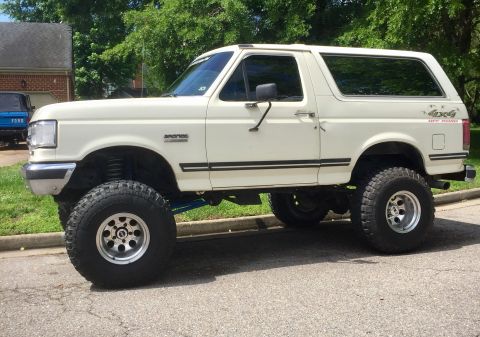 1974 Ford Bronco - This lifted white Ford Bronco features a '4x4 Off Road' decal on the rear quarter panel and appears to be from the early 1990s.