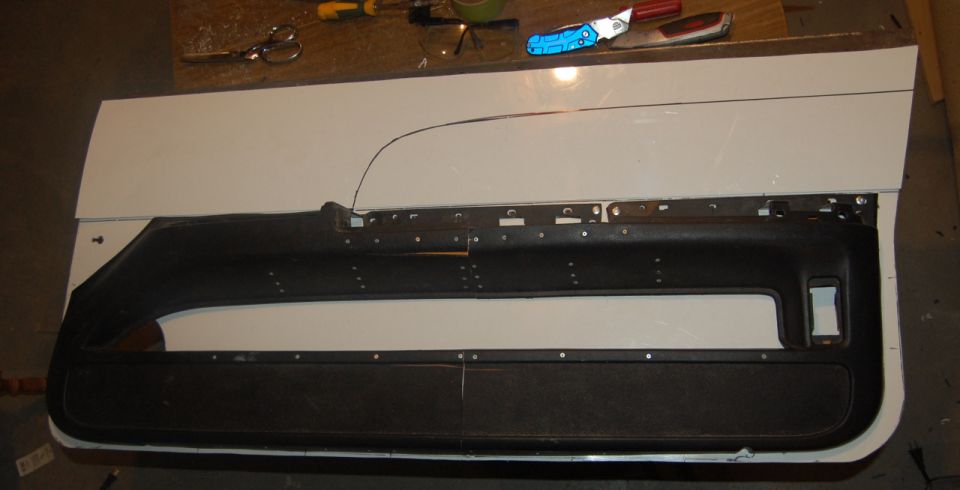 Car door panel laid out on a white surface with tools on top