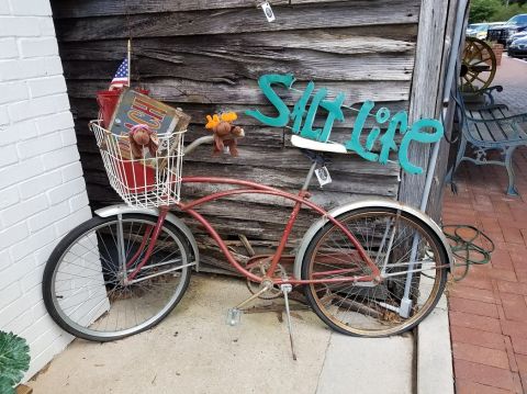 1978 Ford Bronco - Bicycle decorated with a basket, flag, and 'Salt Life' sign against a wooden wall.