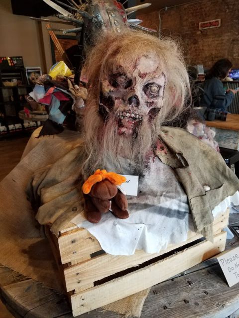 1978 Ford Bronco - A disturbing zombie prop is displayed indoors, complete with a plush toy and a warning sign.