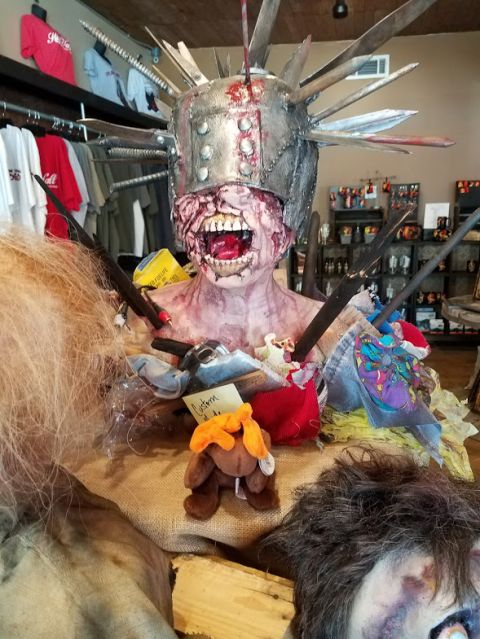 1978 Ford Bronco - A disturbing horror prop with a spiked helmet and bloody face is displayed with various items.