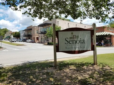 1978 Ford Bronco - A street scene in Senoia, Georgia, shows buildings and a sign with the town's name.