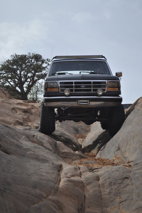 1991 Ford Bronco - This black Ford Bronco navigates a rocky trail with its front end lifted.