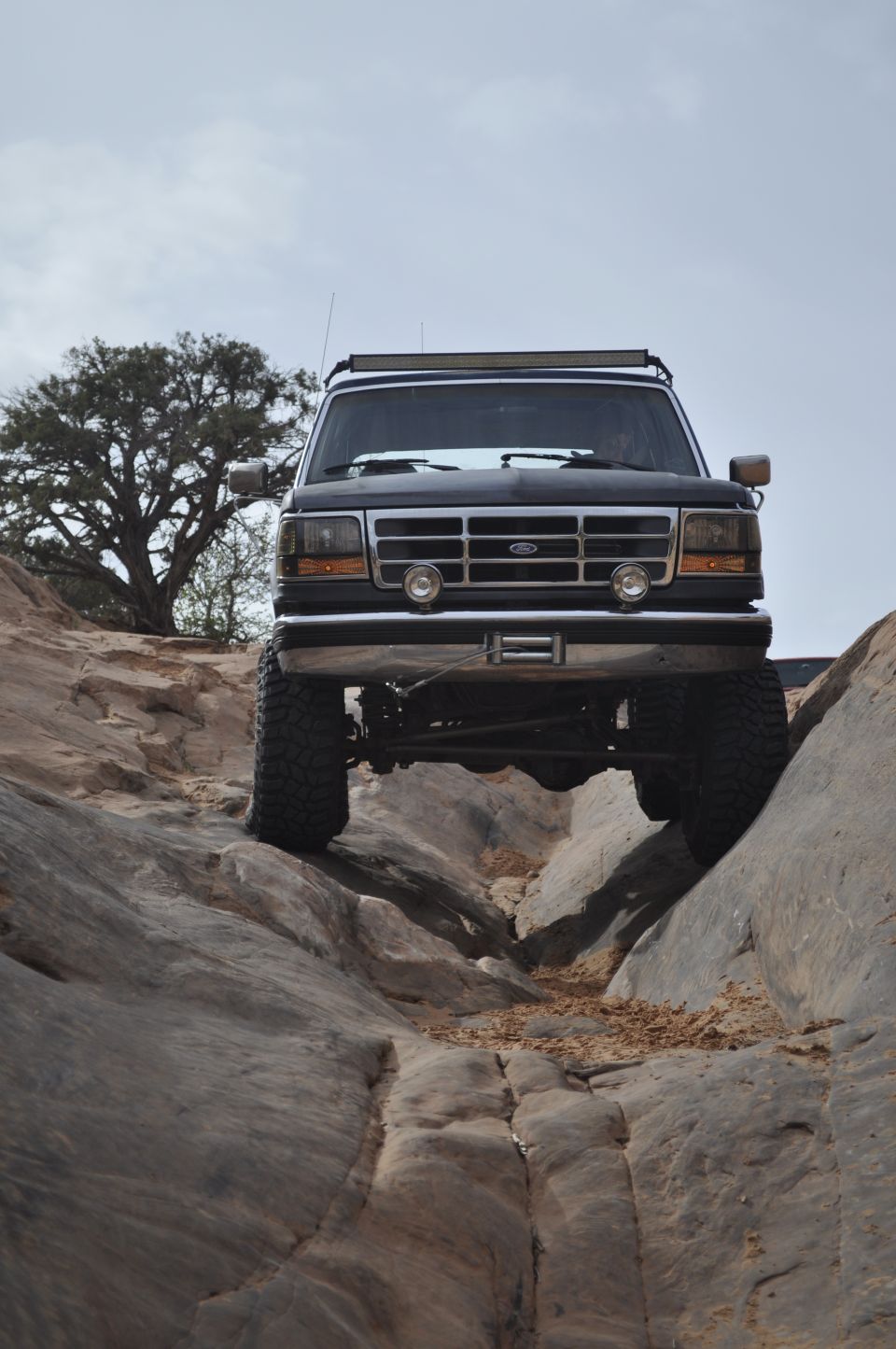 Black 1992 Ford Bronco front view, tires on rocks