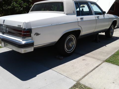 1984 Buick Electra - White 1984 Buick Electra Park Avenue sedan is raised on jack stands for maintenance.