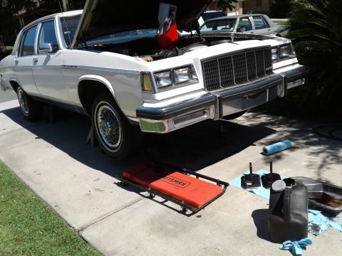 1984 Buick Electra - White 1984 Buick Electra undergoing maintenance with the hood open and tools laid out.