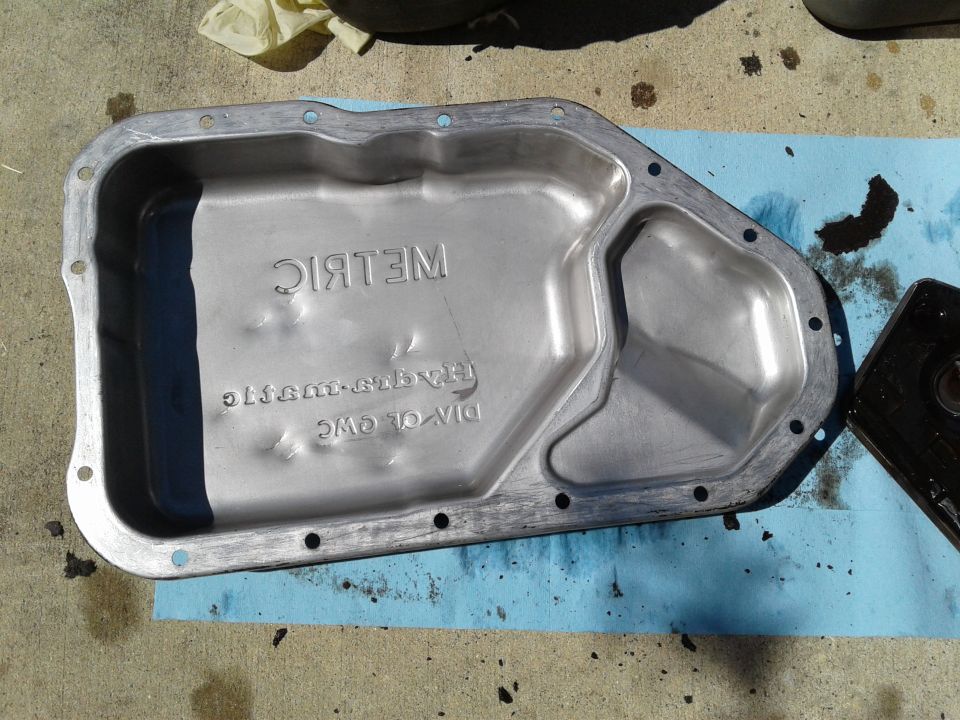Transmission oil pan with "METRIC" stamped on it, also has "DIV. OF GWC" and "TRANS-SUBARU" stamped
