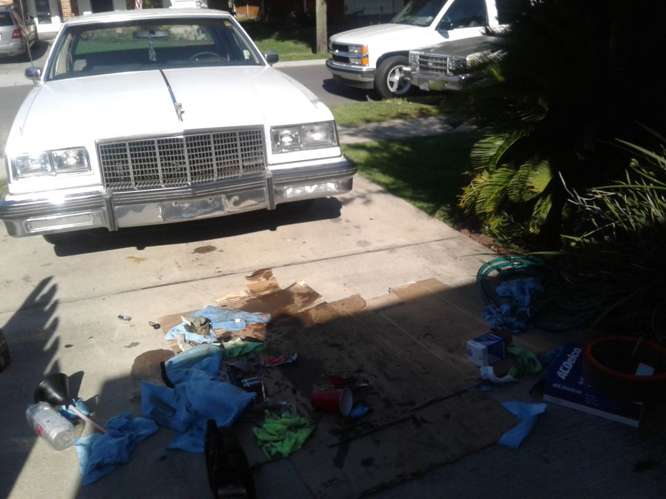 1984 Buick Electra Park Avenue front view, parked in driveway with a white pickup truck behind it