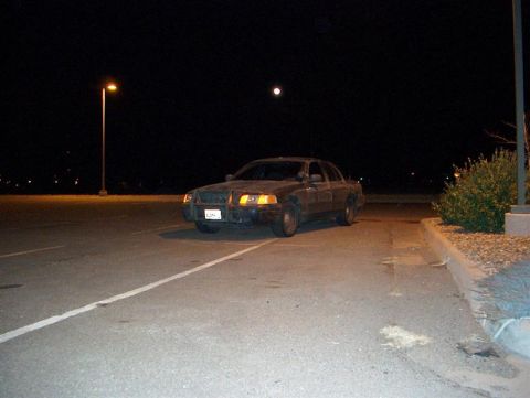 2001 Ford Crown Victoria - A 2001 Ford Crown Victoria is parked in a lot at night under a full moon.