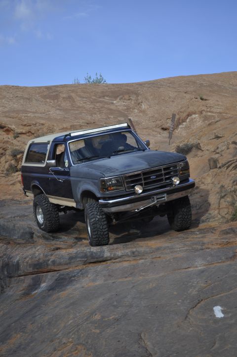 1991 Ford Bronco - This 1991 Ford Bronco navigates a challenging rocky trail under a clear blue sky.